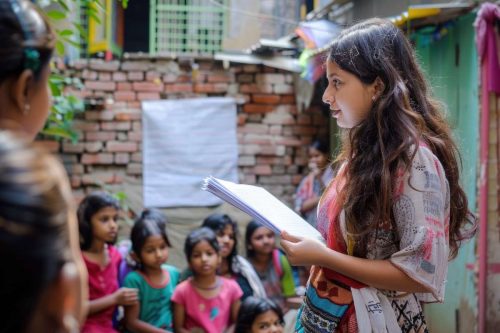against-backdrop-bustling-city-indian-girl-volunteers-community-center-tutoring-children-offering-them-mentorship-guidance-with-care-dedication (1)
